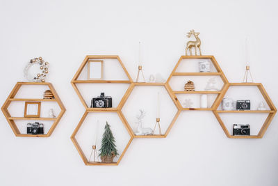 Pine wood hexagonal shelves on the wall with a variety of christmas decorations.