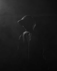 Side view of woman against black background