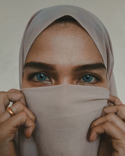 Close-up portrait of a young woman covering face