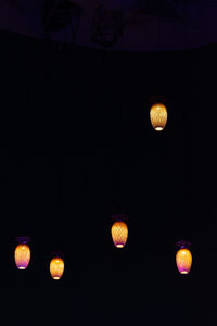 Low angle view of illuminated lanterns hanging at night