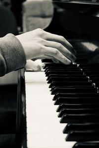 Cropped hands of person playing piano
