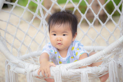 Portrait of cute baby girl looking at fence