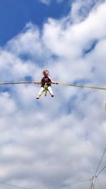 Low angle view of girl bungee trampoline against sky
