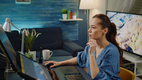 Young woman using laptop at cafe