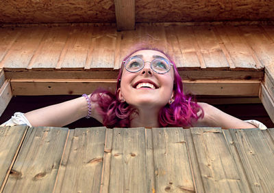 Portrait of happy woman lying on wooden floor