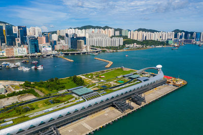 High angle view of city by sea against sky