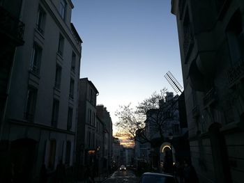 Cars on street amidst buildings against clear sky