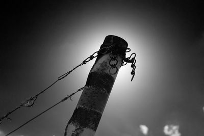 Low angle view of wooden post against sky