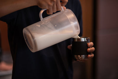 Close-up of man pouring coffee in cup