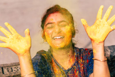 Close-up of smiling woman covered with powder paint