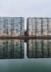 Reflection of building in city against sky