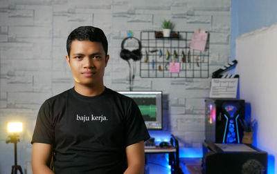 Portrait of young man standing in office