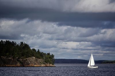 Sailboat sailing on sea against sky