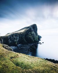 Scenic view of rocks by sea against sky