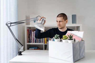 Man arranging lighting equipment on table