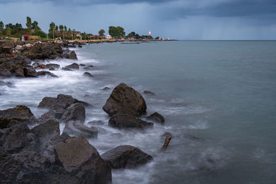 Scenic view of rocks in sea against sky