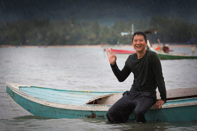 Portrait of young man in sea against sky