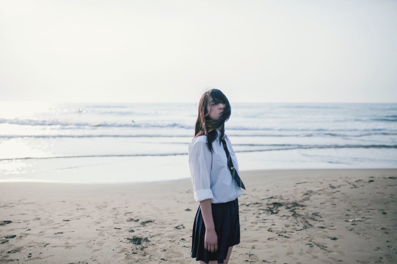 WOMAN STANDING ON BEACH