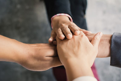 Cropped image of colleagues with stacked hands over table