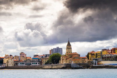 River in city against cloudy sky