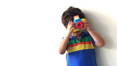 Boy playing with multi colored background