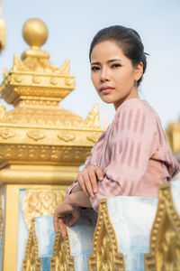 Portrait of woman standing by railing