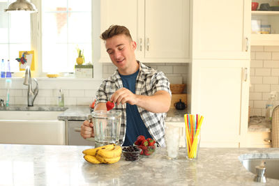 Portrait of young man preparing food at home