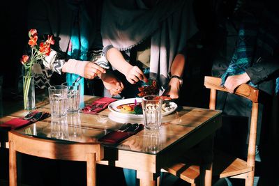 Close-up of hand holding drink on table