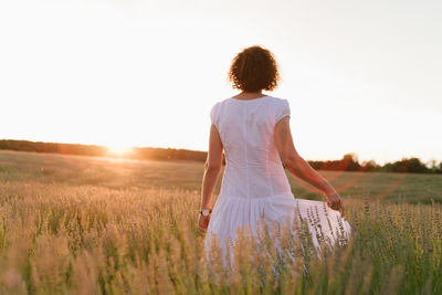 Woman standing on field against sky