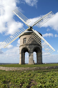 Traditional windmill on field against sky