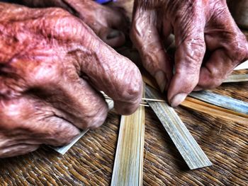 Cropped image of person weaving wicker