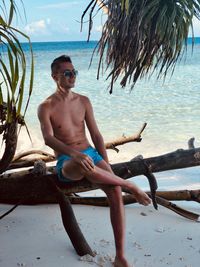 Portrait of young man sitting on beach