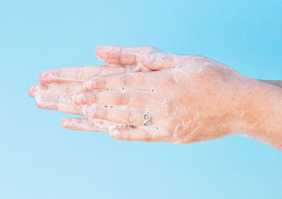 Close-up of hand against blue background