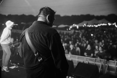Rear view of man looking at city at night