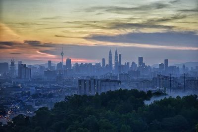 View of cityscape against cloudy sky during sunset