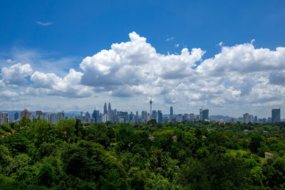 View of cityscape against cloudy sky