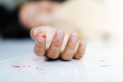 Close-up of person with wounded hand lying on floor