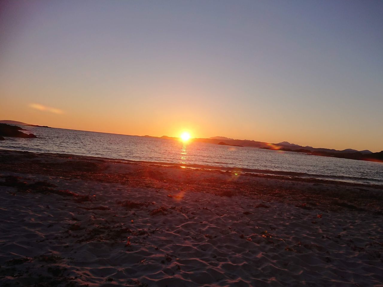 SCENIC VIEW OF BEACH AGAINST SKY DURING SUNSET