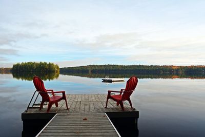 Chairs on a dock on early morning lake