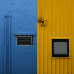 Close-up of yellow mailbox on blue door