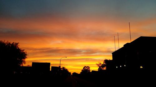 High section of silhouette built structures against scenic sky