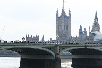 View of bridge over river in city against sky