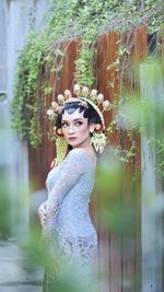 Portrait of young woman wearing hijab while standing against trees