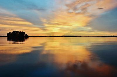 Scenic view of lake against sky at sunset