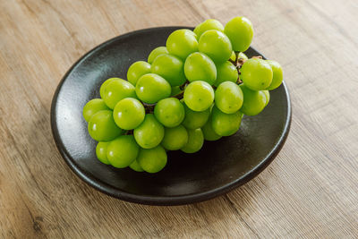 High angle view of grapes in bowl on table