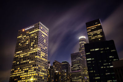 Low angle view of illuminated buildings against sky at night