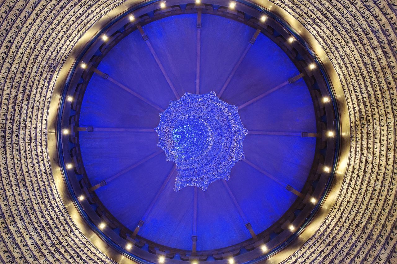 LOW ANGLE VIEW OF ILLUMINATED CHANDELIER HANGING FROM CEILING