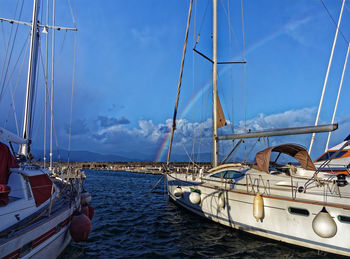 Sailboats moored on sea against sky