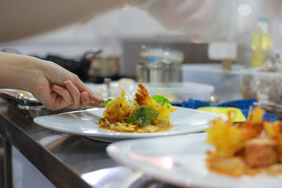 Close-up of hand holding food in plate