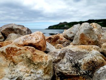 Close-up of rocks on shore against sky